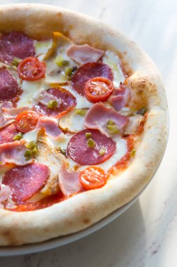 Beyaz kafe masasında fırında pişmiş Napoli biberli pizza.