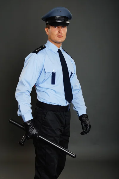 Поліцейський тримає під рукою поліцейську паличку — стокове фото