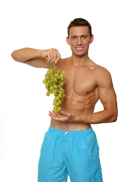 Hombre sin camisa sostiene en las manos uvas —  Fotos de Stock