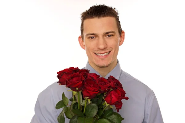 Young man holds bouquet of red roses — Stock Photo, Image