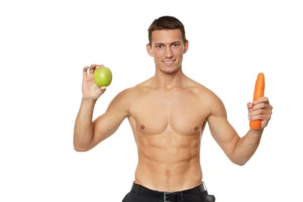 Mann hält Apfel und Karotte in den Händen — Stockfoto