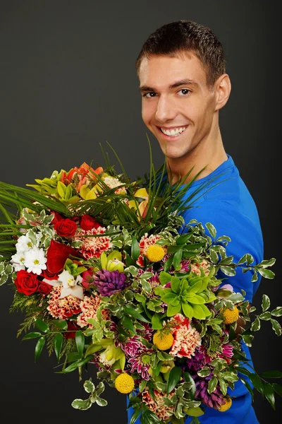 Young man with flowers — Stock Photo, Image