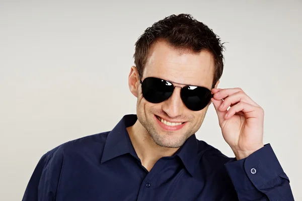 Hombre guapo sosteniendo gafas de sol —  Fotos de Stock