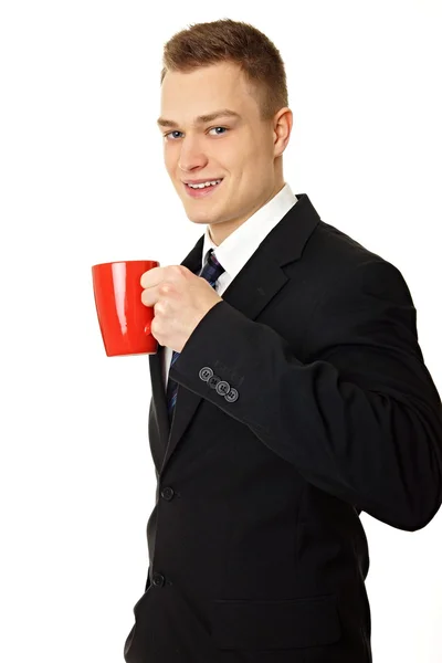 Man in black suit drinks coffee — Stock Photo, Image