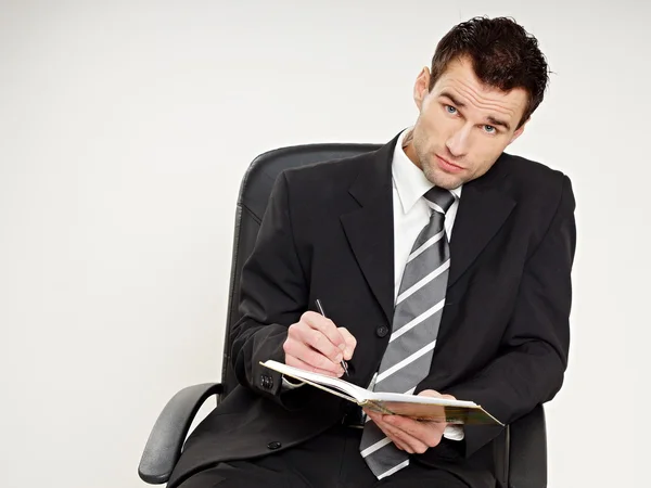 Businessman writes in notebook — Stock Photo, Image