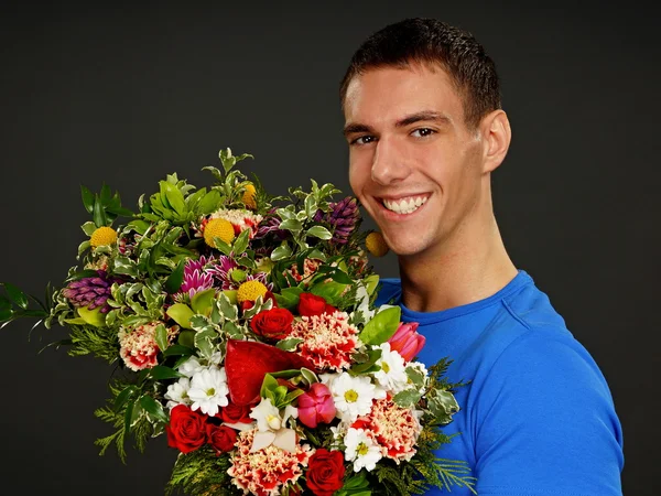 Young man with flowers — Stock Photo, Image