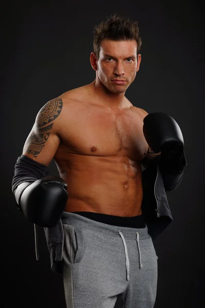 Uomo muscolare posa con i guanti boxer — Foto Stock