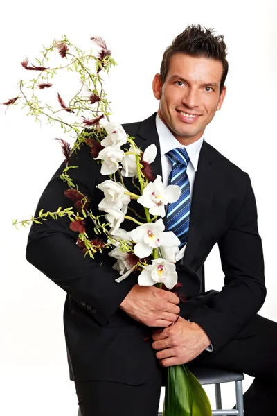 Empresário de terno com flores de orquídea — Fotografia de Stock