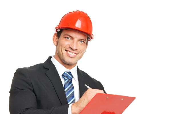 Businessman in helmet writes some document — Stock Photo, Image