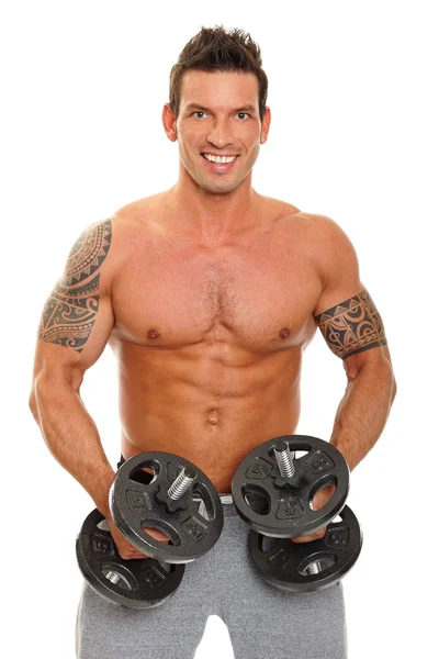 Muskulöser Mann posiert mit Hanteln — Stockfoto