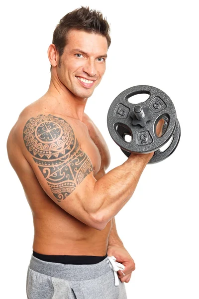 Muskulöser Mann posiert mit Hantel — Stockfoto