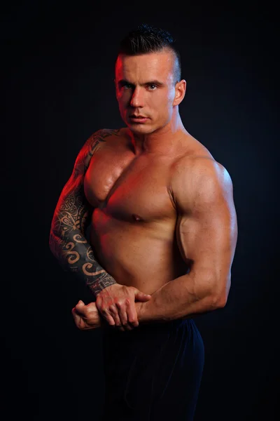 Muscular man shows his muscles — Stock Photo, Image