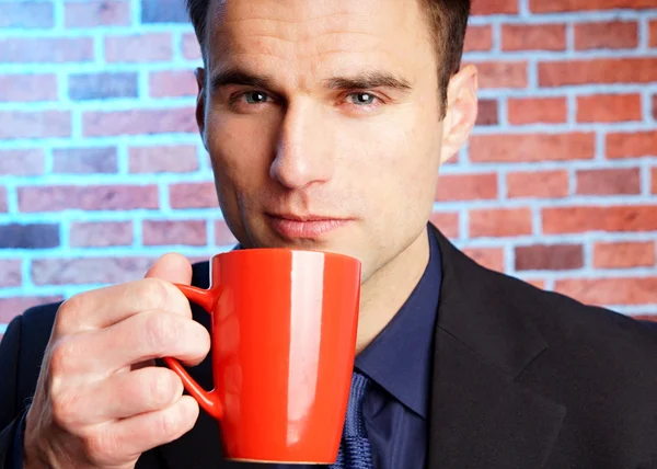 Бизнесмен держит чашку кофе — стоковое фото