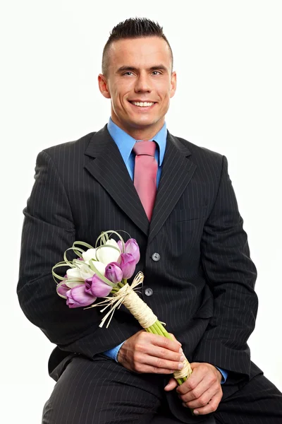 Smiling man holds flowers — Stock Photo, Image