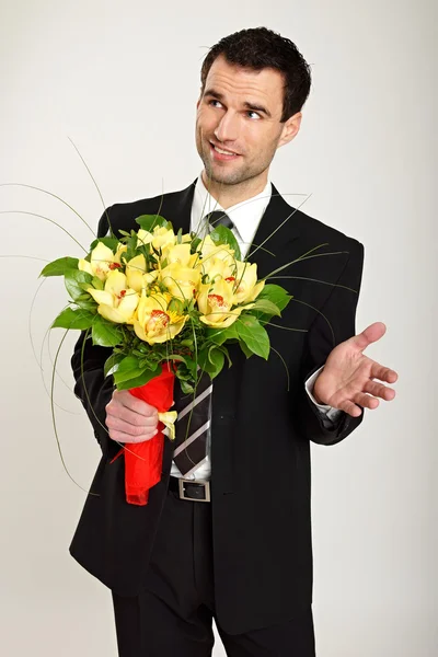 Knappe man met een boeket van orchideeën — Stockfoto