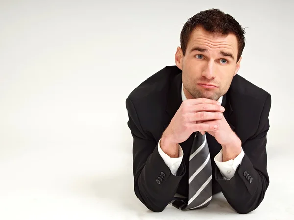 Thinking businessman lying on the floor — Stock Photo, Image