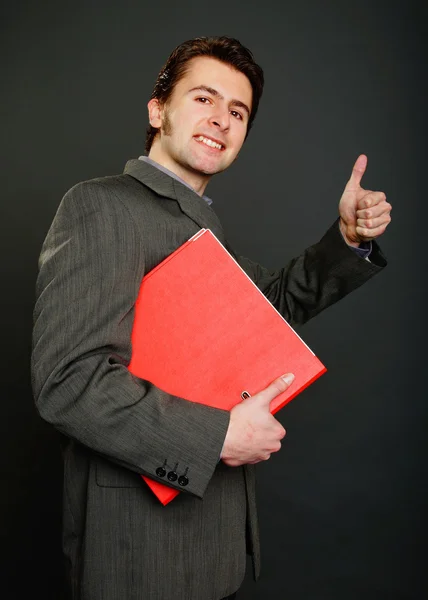 Man in suit holds red worktops — Stock Photo, Image