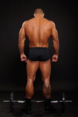 Kaslı adam halterle ayakta