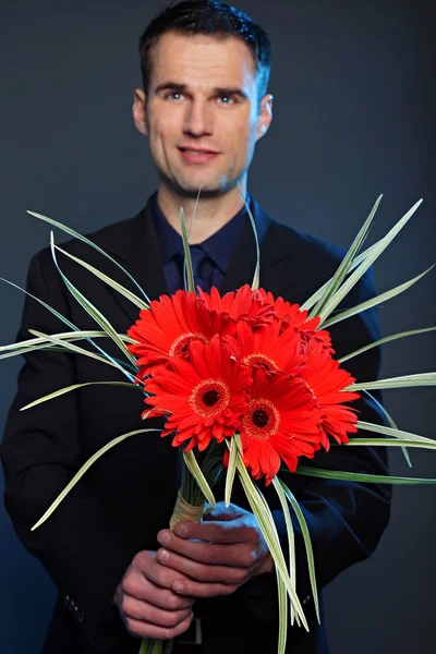 Empresário com flores de gerberas — Fotografia de Stock