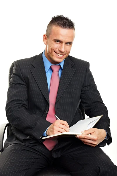 Handsome man writes some document — Stock Photo, Image