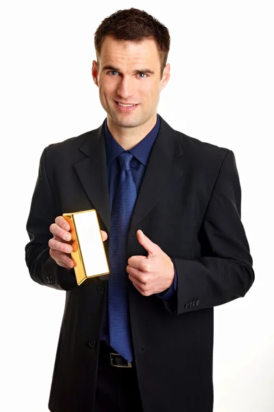 Бизнесмен держит золотой кирпич — стоковое фото