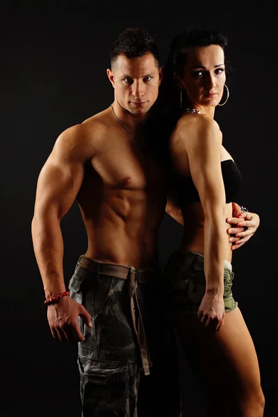 Muscular man poses with his girlfriend — Stock Photo, Image
