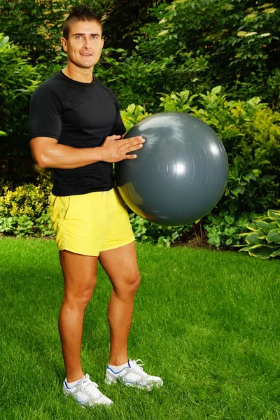 Man med fitness boll bakom huvudet — Stockfoto