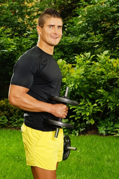 Man exercises with dumbbells — Stock Photo, Image