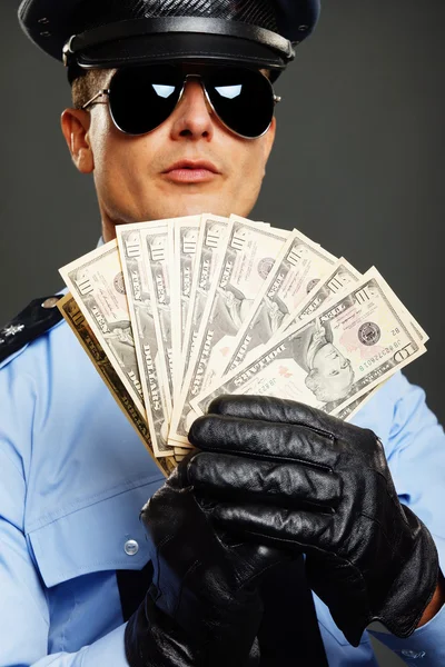 Полицейский показывает деньги — стоковое фото