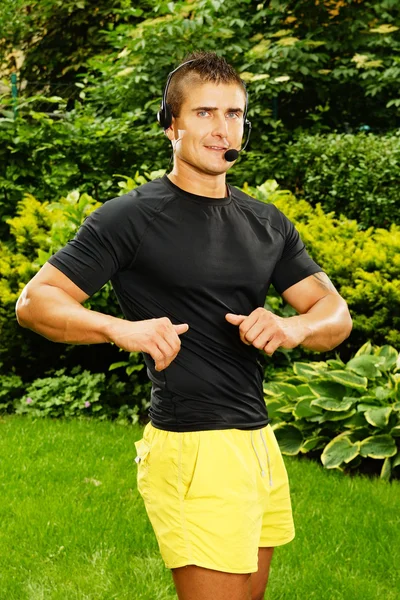 Aerobics male coach exercises in garden — Stock Photo, Image