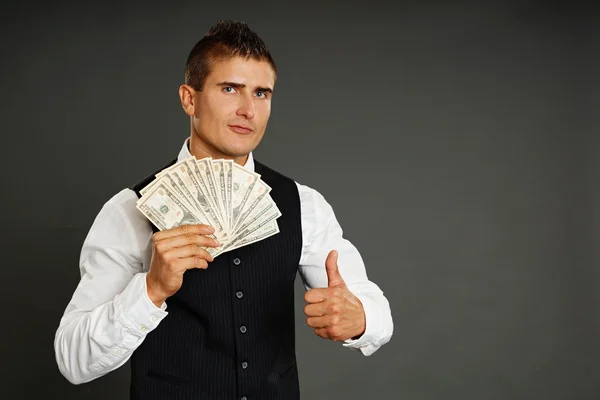 Homem posa com dinheiro e gesto polegar para cima — Fotografia de Stock