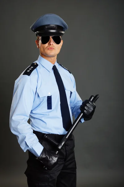 Policeman holds at hand police baton — Stock Photo, Image