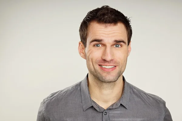 Joven sonriente con camisa gris — Foto de Stock