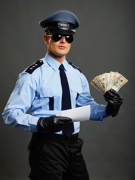 Полицейский показывает вам деньги и документ — стоковое фото