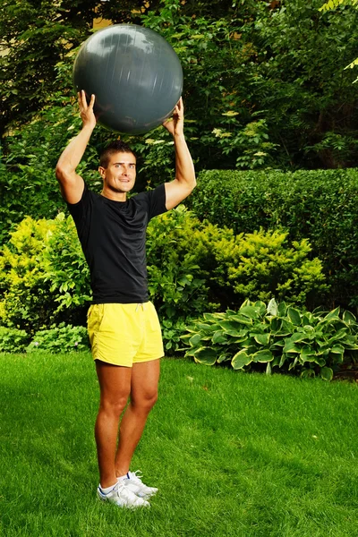 Man med fitness boll bakom huvudet — Stockfoto