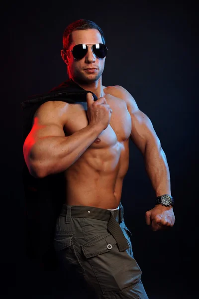 Muscular man with jacket over shoulder — Stock Photo, Image