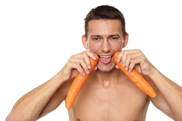 Człowiek posiadający marchew w pobliżu jego usta — Zdjęcie stockowe