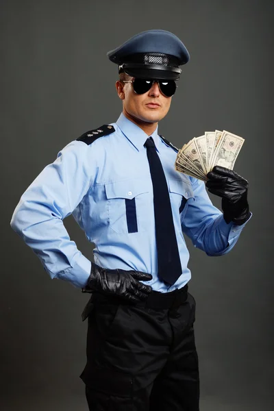 Policeman shows money — Stock Photo, Image