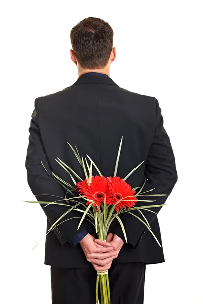 Man with flowers behind his back — Stock Photo, Image