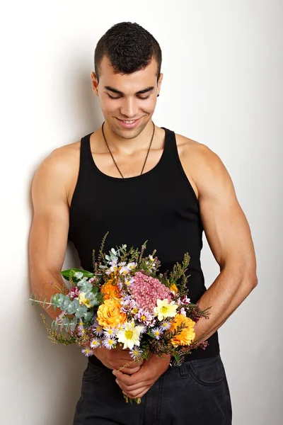 Sonriente hombre sostiene ramo de flores —  Fotos de Stock