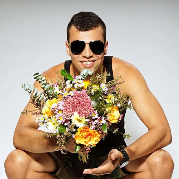 Soldier holds bouquet of flowers — Stock Photo, Image