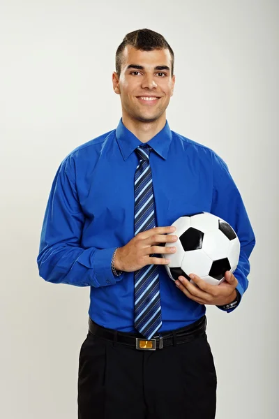 İşadamı bir futbol topu tutuyor — Stok fotoğraf