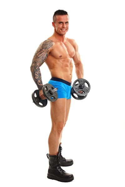 Muscular man poses with dumbbells — Stock Photo, Image