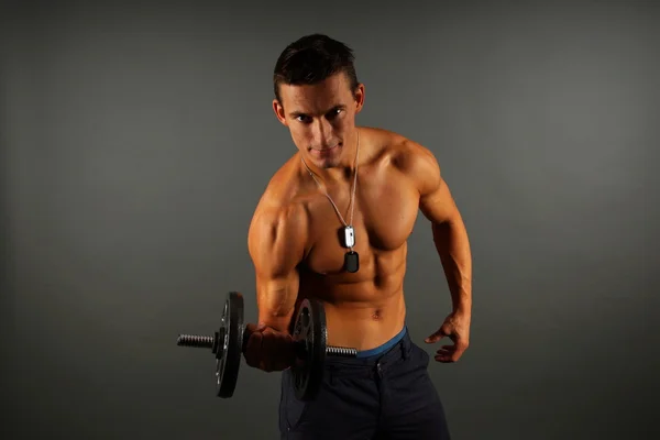 Muscular man poses with dumbbell — Stock Photo, Image