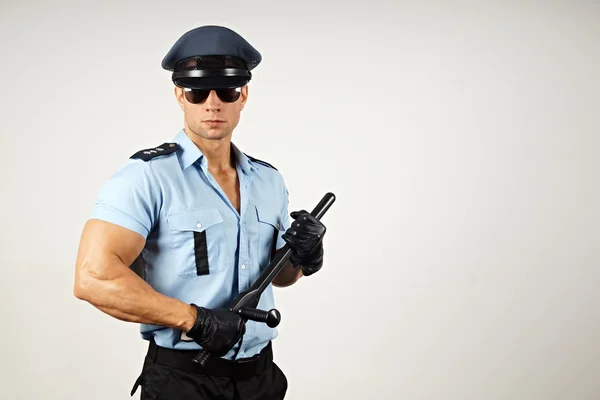 Policeman holds nightstick in hands — Stock Photo, Image