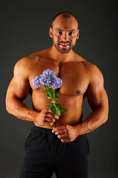 Portrait of muscular man with flower — Stock Photo, Image