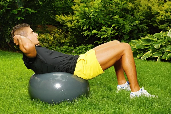 Exercícios de homem com a bola de fitness — Fotografia de Stock