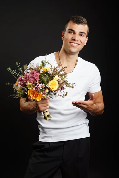 Lächelnder Mann hält Blumenstrauß in der Hand — Stockfoto