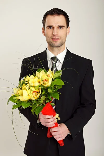 Zakenman houdt boeket van orchideeën — Stockfoto