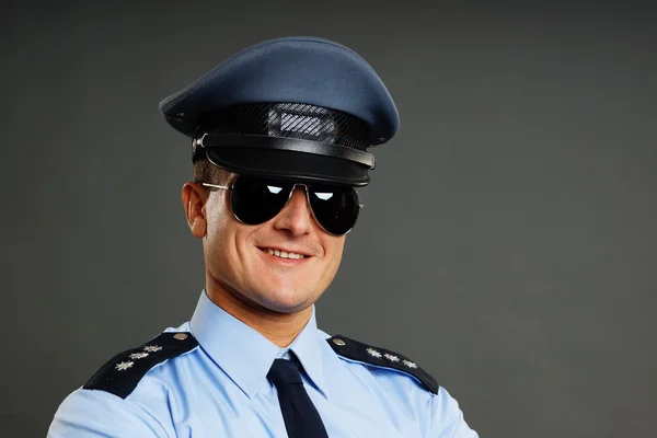 Улыбающийся полицейский в солнечных очках — стоковое фото